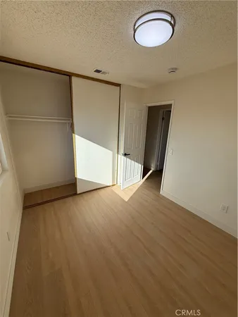 an empty room with wooden floor and mirror