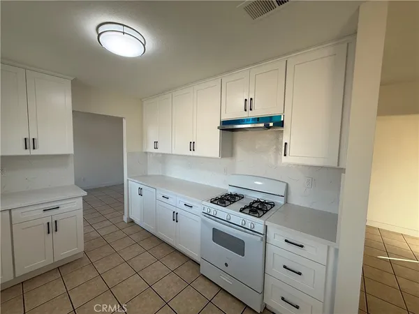 a kitchen with granite countertop white cabinets and white appliances