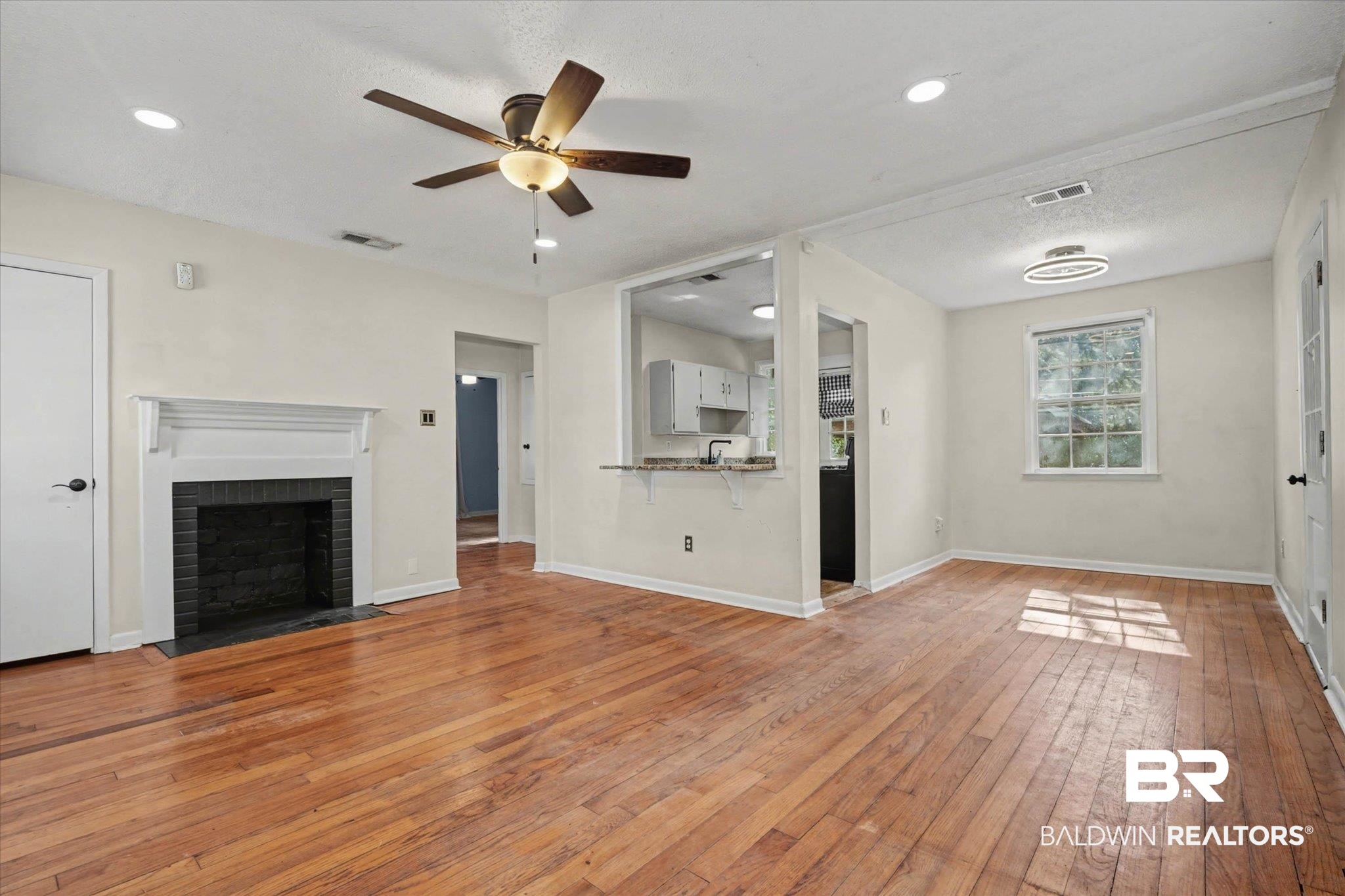 5117 Norton Lane Mobile, AL 36608 - Photo 6 of 35 Unfurnished living room featuring light wood-style flooring, a brick fireplace, a ceiling fan, and recessed lighting