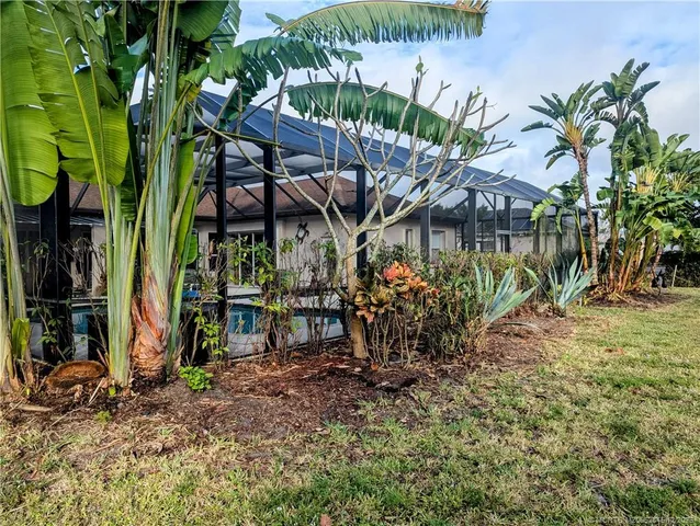 a view of a wooden house with a yard and sitting area