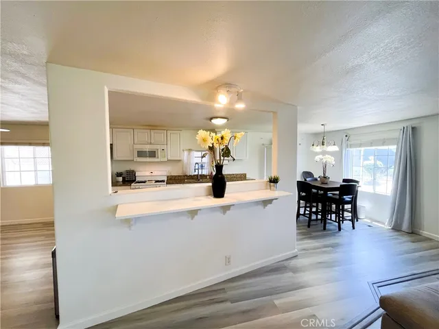 a view of kitchen with dining table wooden floor and living room