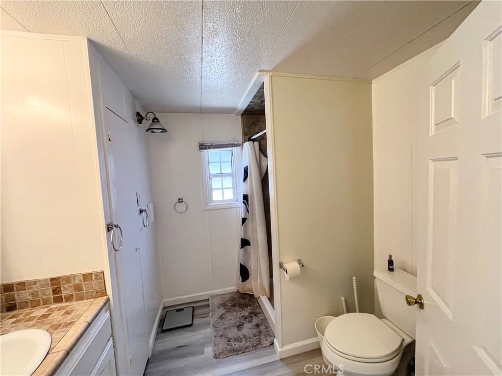 17700 Avalon Boulevard, Unit 40 Carson, CA 90746 - Photo 22 of 32 a bathroom with a granite countertop sink toilet and shower