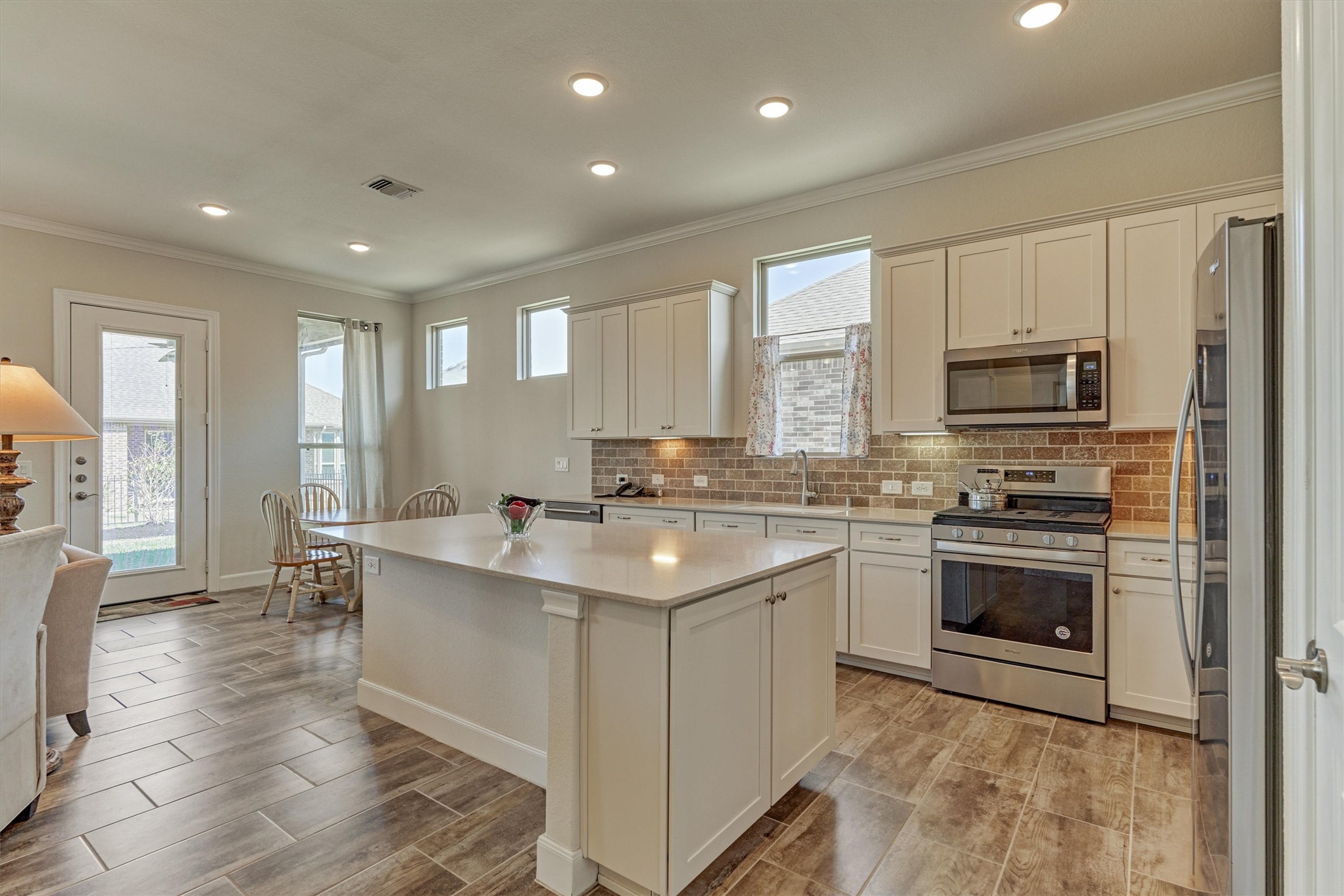 132 Chestnut Bay Spring, TX 77382 - Photo 18 of 33 a kitchen with stainless steel appliances granite countertop a stove top oven a sink dishwasher a refrigerator and white cabinets with wooden floor