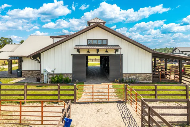 a kitchen with stainless steel appliances granite countertop a table chairs sink and cabinets