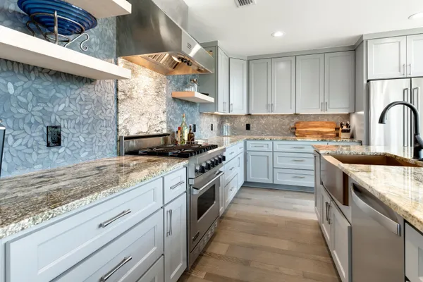 a kitchen with granite countertop white cabinets and stainless steel appliances