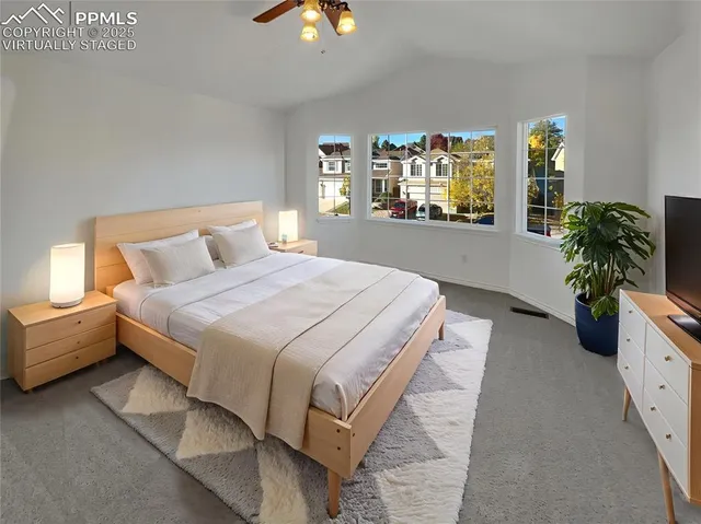 a spacious bedroom with a large bed and a potted plant