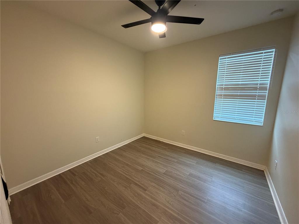 9448 Sanders Pk Place Seffner, FL 33584 - Photo 12 of 21 an empty room with wooden floor and windows