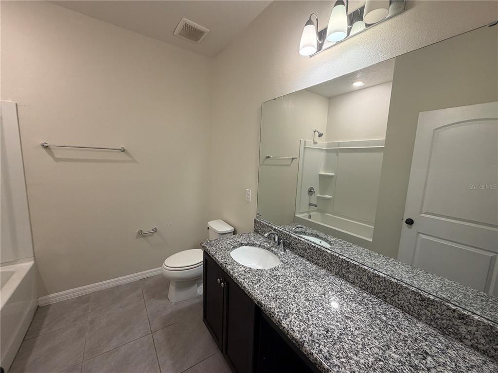 9448 Sanders Pk Place Seffner, FL 33584 - Photo 13 of 21 a bathroom with a granite countertop sink a toilet and shower