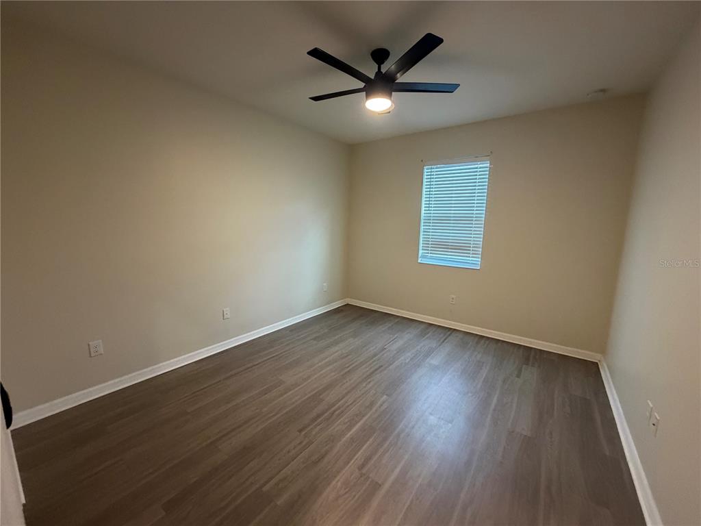 9448 Sanders Pk Place Seffner, FL 33584 - Photo 7 of 21 an empty room with wooden floor and windows