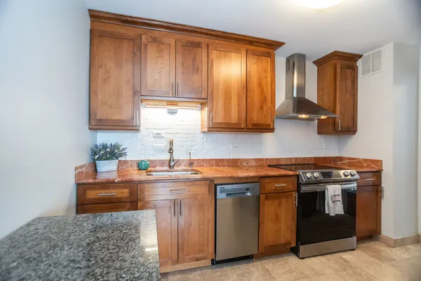 a kitchen with stainless steel appliances granite countertop a stove a sink and a microwave