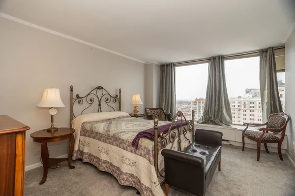 a bedroom with a bed and a large window