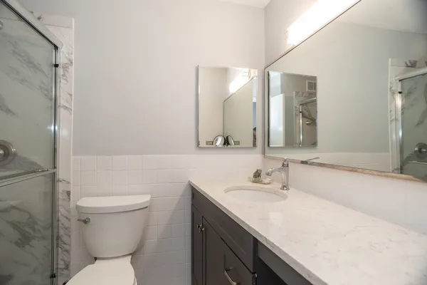 a bathroom with a sink toilet vanity and shower