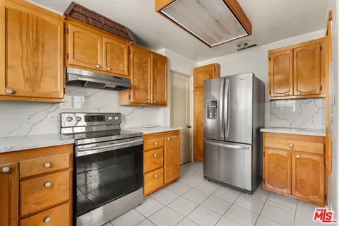 a kitchen with stainless steel appliances granite countertop a refrigerator and a stove