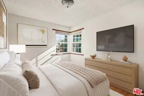 a bedroom with a large bed and a flat screen tv