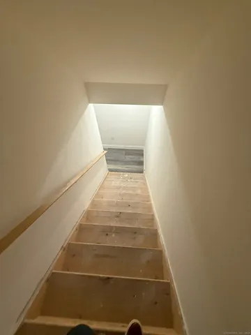an empty room with wooden floor and mirror on vanity