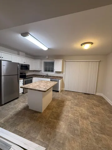 a view of kitchen with refrigerator sink and stove