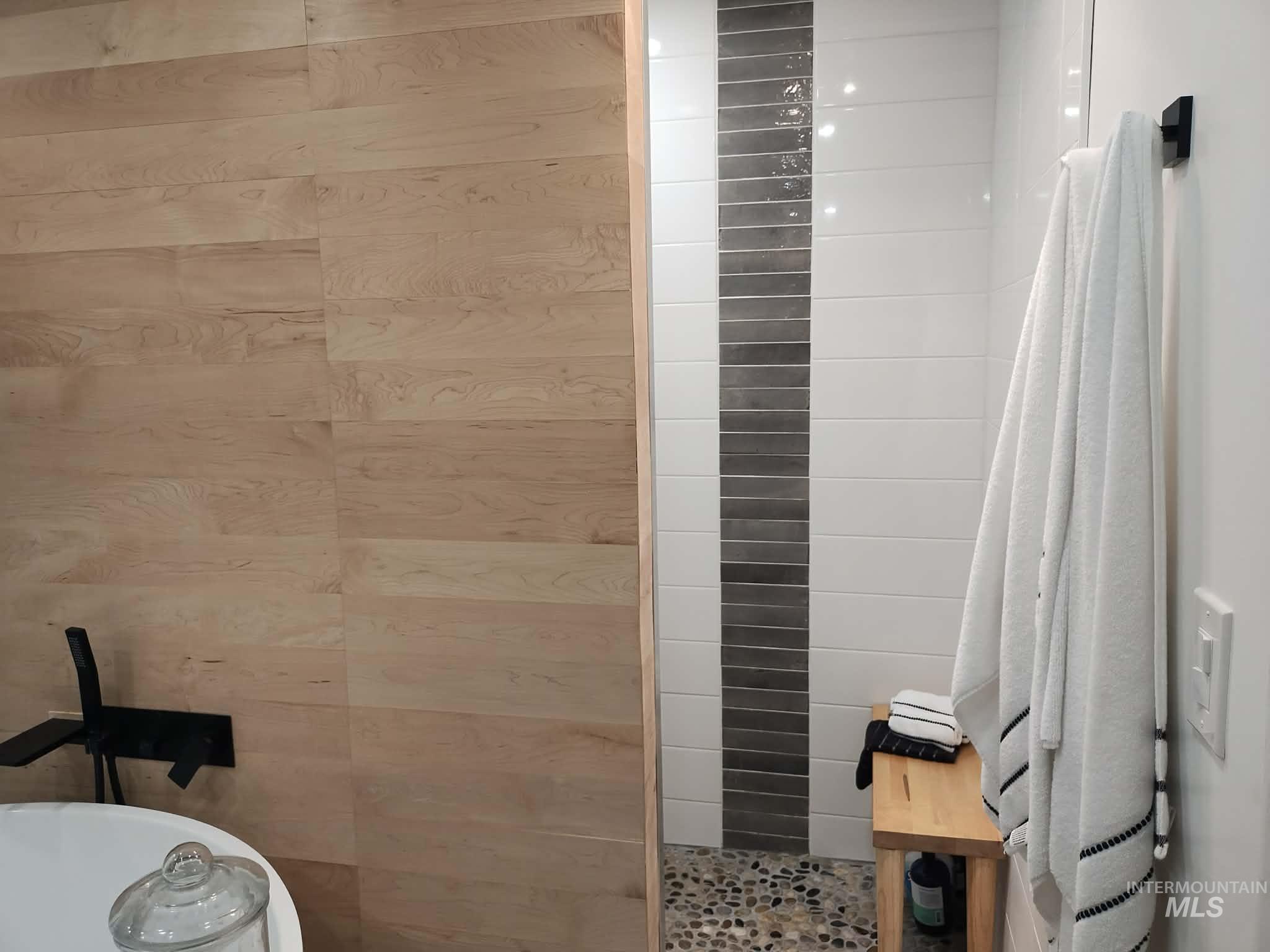 14526 Perfection Lane Caldwell, ID 83607 - Photo 22 of 47 Modern bathroom featuring wood-finish wall paneling and a freestanding soaking tub with a wall-mounted matte black faucet