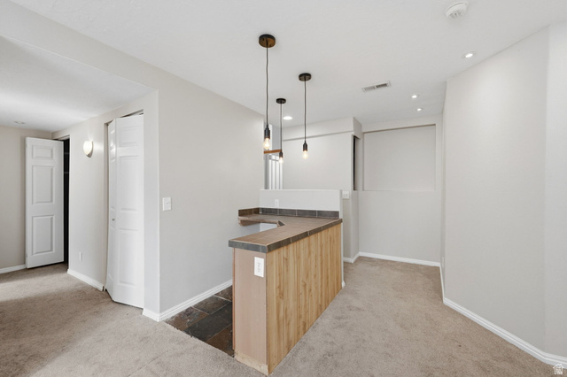 2575 Athena Drive Magna, UT 84044 - Photo 15 of 23 Custom bar area featuring wood-finish paneling, a dark countertop, and three pendant lights