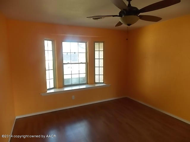 6001 Jameson Road Amarillo, TX 79106 - Photo 6 of 22 a view of an empty room with a window and wooden floor