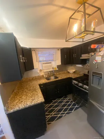 a kitchen with granite countertop a stove and a wooden cabinets
