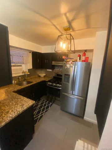 a kitchen with stainless steel appliances granite countertop a refrigerator and a stove