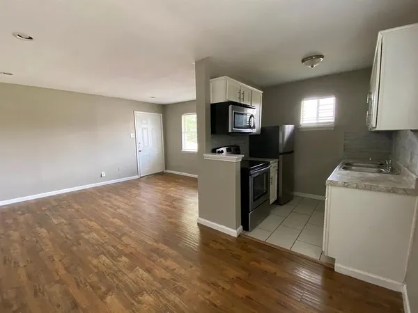 a kitchen with granite countertop a stove a sink and a microwave