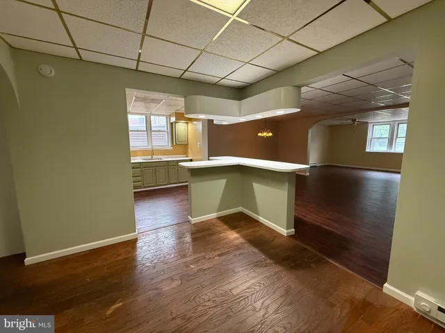 a view of a kitchen with a fridge and wooden floor