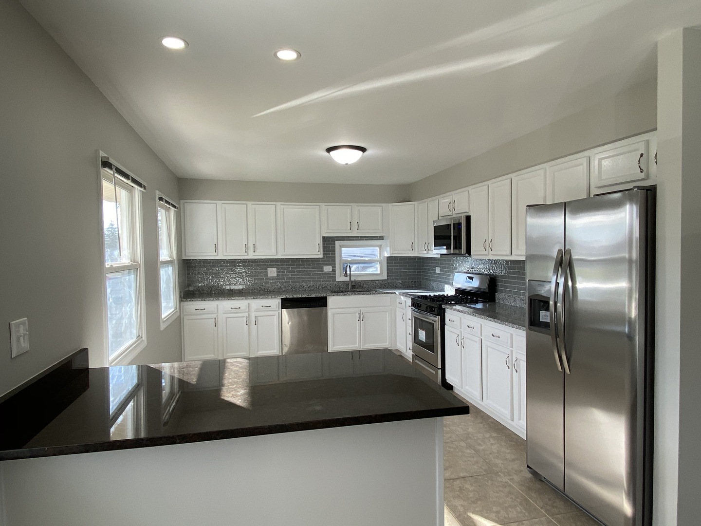 18 South Oltendorf Road Streamwood, IL 60107 - Photo 2 of 21 a kitchen with stainless steel appliances granite countertop a refrigerator a stove a sink a microwave and white cabinets