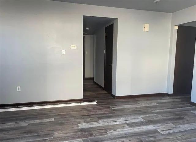 a view of a livingroom with wooden floor and refrigerator