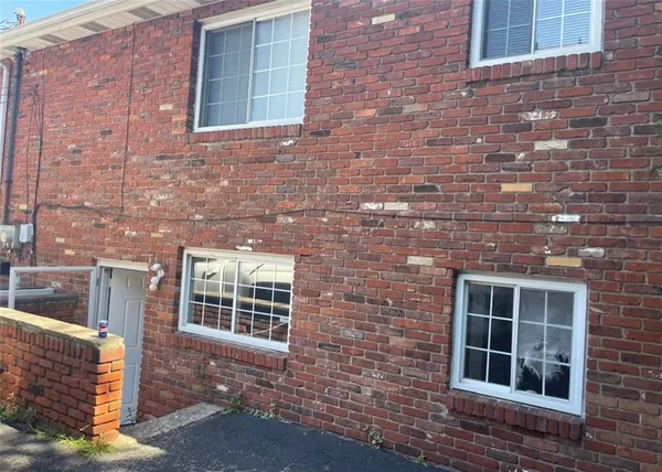 a view of front of a brick house with large windows