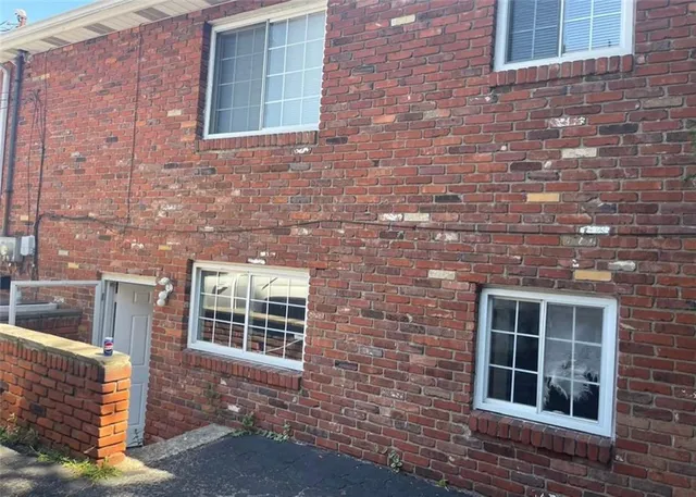 a view of front of a brick house with large windows