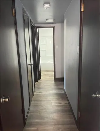a view of a hallway with wooden floor