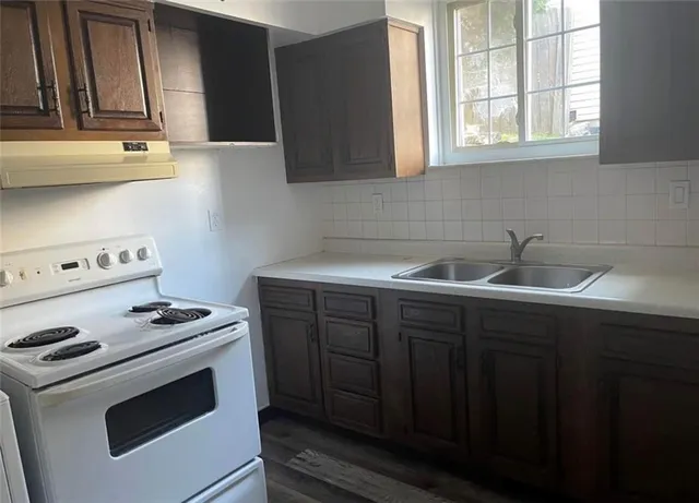 a kitchen with sink a stove and cabinets