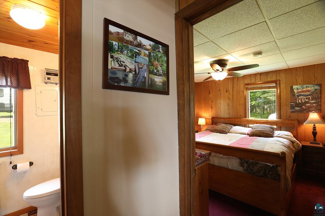 1198 West Mink Road Cotton, MN 55724 - Photo 10 of 23 Bedroom featuring wood walls and ensuite bath