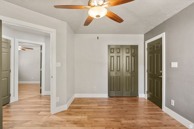 55 Spring Drive Toquerville, UT 84774 - Photo 20 of 36 Unfurnished bedroom 3 featuring light wood-type flooring, a textured ceiling, a ceiling fan, and a closet