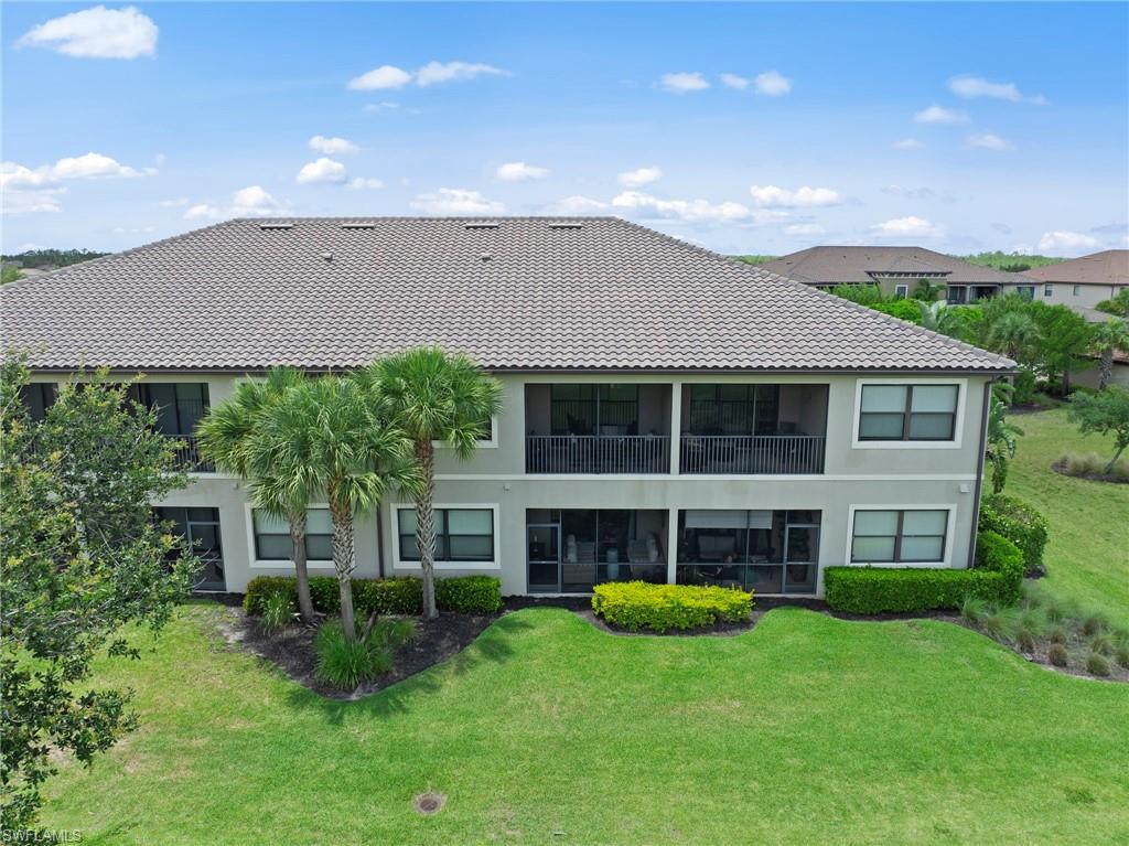 9366 Pocida Court, Unit 202 Naples, FL 34119 - Photo 27 of 44 a view of an house with backyard and a garden