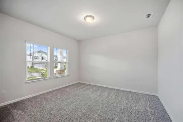 a view of an empty room with a kitchen and a fireplace