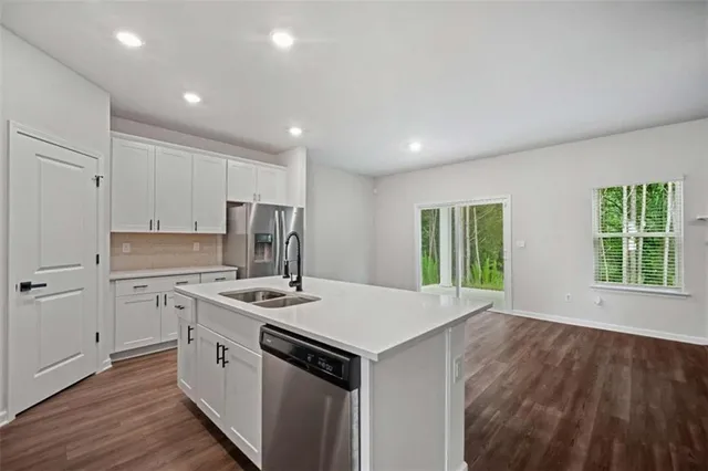 a kitchen with kitchen island a white counter top space cabinets and stainless steel appliances