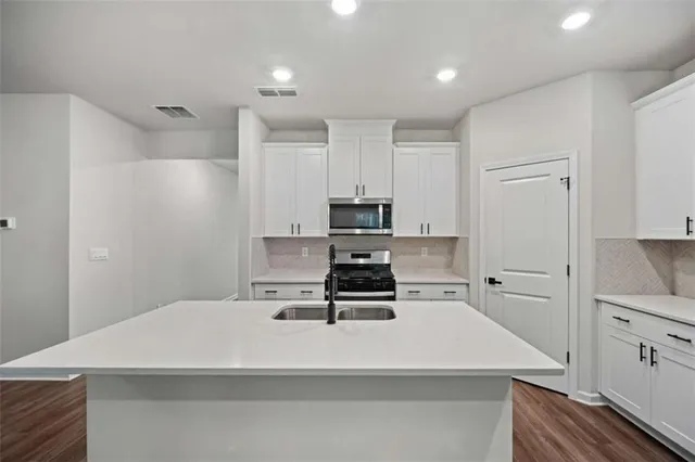 a kitchen with stainless steel appliances a refrigerator stove microwave and cabinets