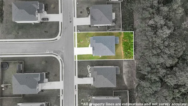 an aerial view of residential houses with yard and ocean view