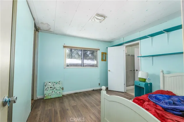 a bedroom with a bed and a painting on the wall