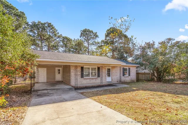 a front view of a house with a yard and trees