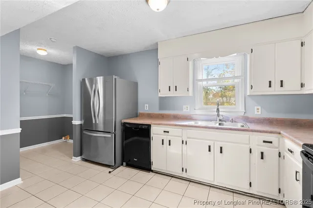 a kitchen with granite countertop a refrigerator sink and cabinets