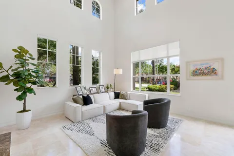 a living room with furniture potted plant and windows