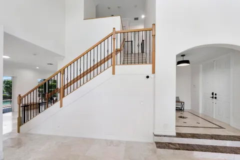 a view of staircase with lots of frames on wall and a potted plant