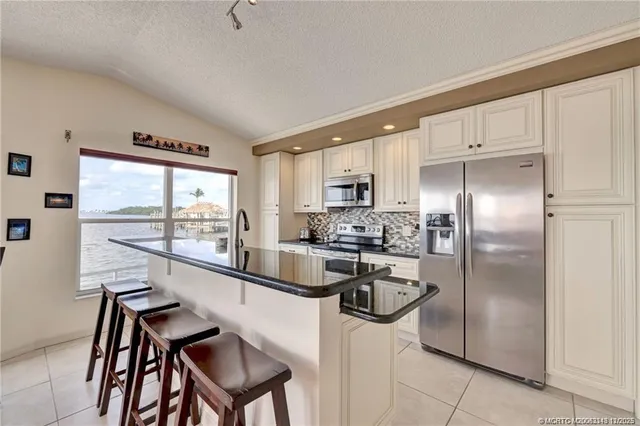 a kitchen with a table chairs refrigerator and microwave