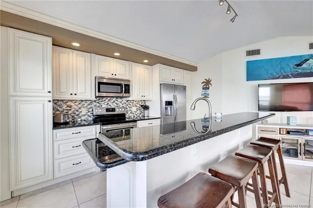 a kitchen with granite countertop stainless steel appliances and white cabinets