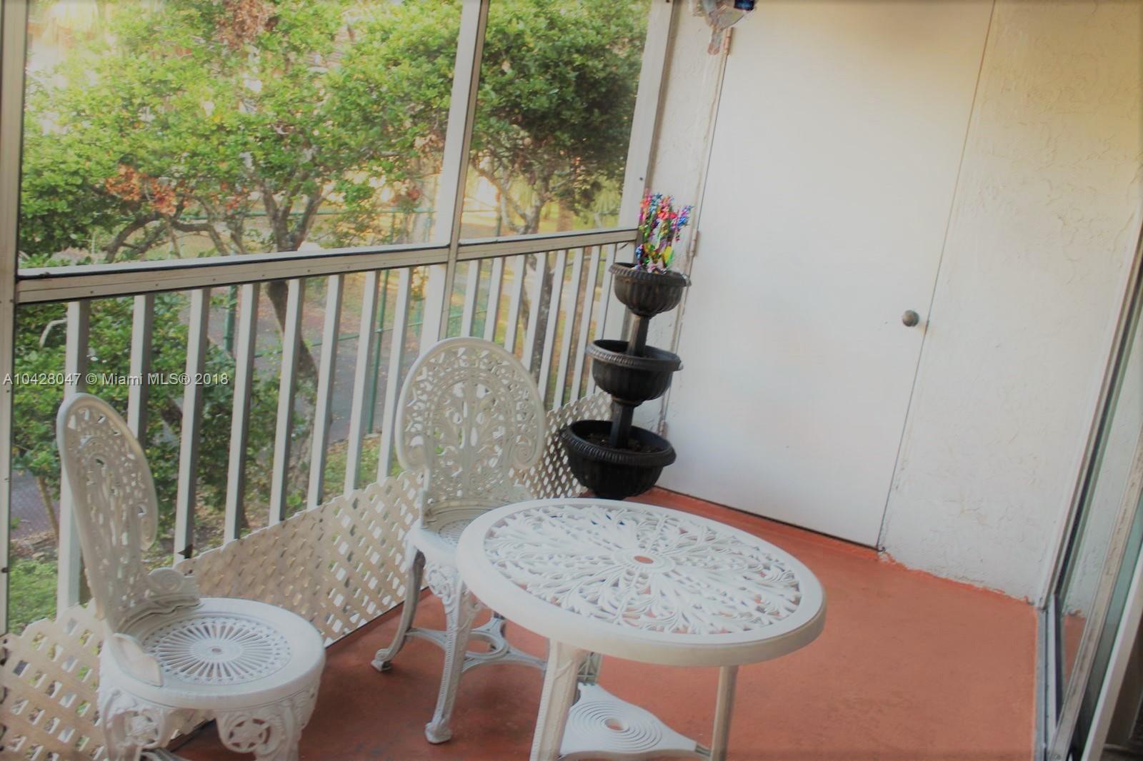 9511 Southwest 138th Place, Unit 9511 Miami, FL 33186 - Photo 12 of 17 a view of a balcony dining table and chairs