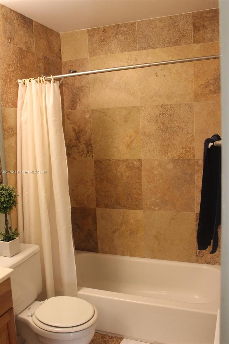 9511 Southwest 138th Place, Unit 9511 Miami, FL 33186 - Photo 14 of 17 a bathroom with a toilet and a bathtub