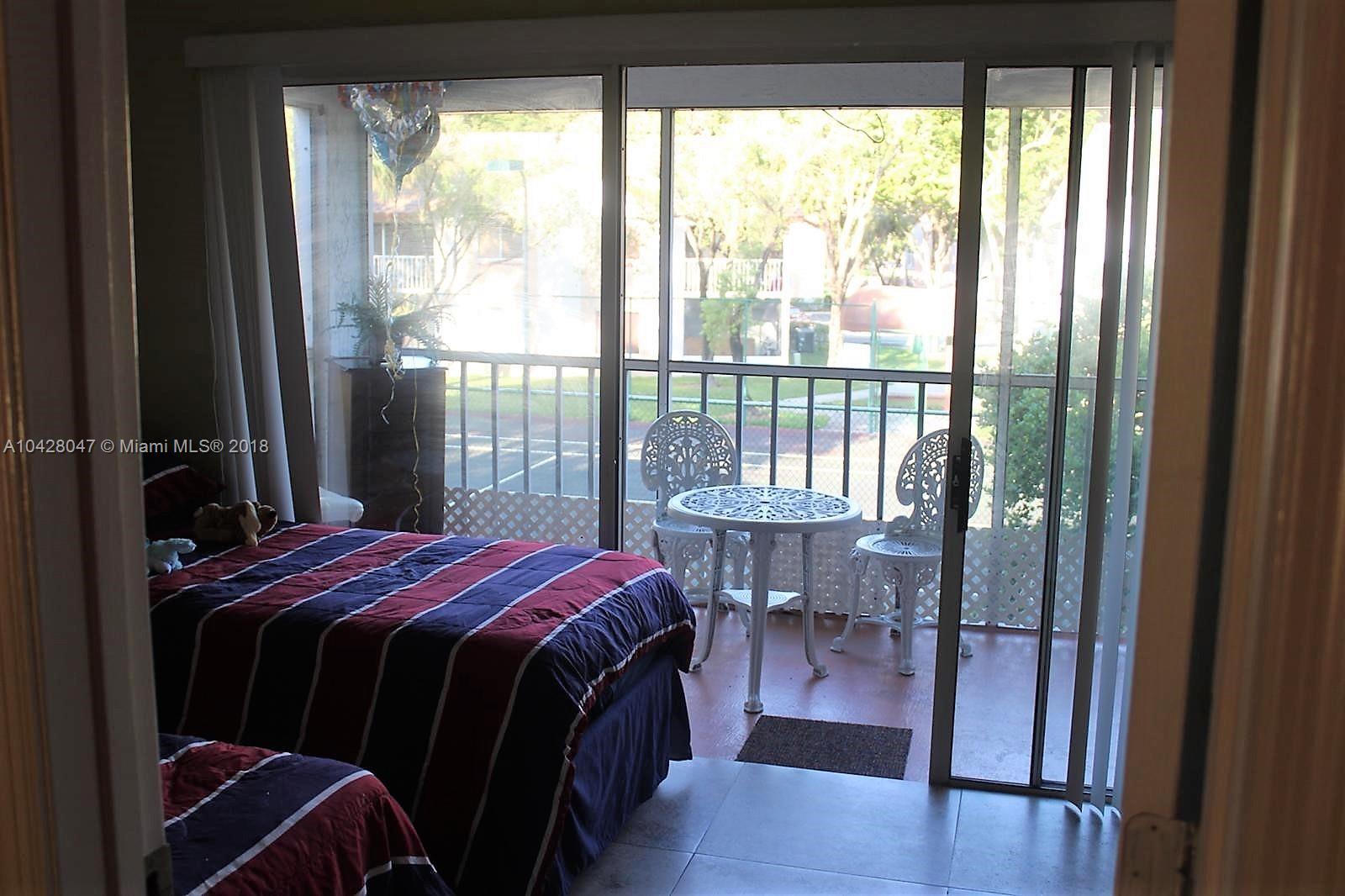 9511 Southwest 138th Place, Unit 9511 Miami, FL 33186 - Photo 10 of 17 a bedroom with a bed and a large window